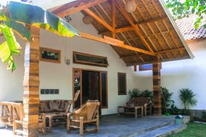 a patio of a house with a wooden roof at Mellow Hostel in Kuta Lombok