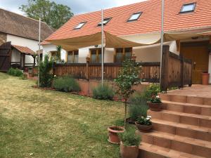 uma casa com um telhado vermelho e um quintal em Levendula Porta és Pajtaszínház em Orfű