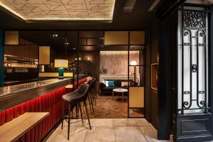 un bar avec tabourets de bar noir et rouge dans l'établissement Hotel Villa Nicolo, à Paris