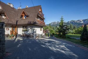 a house with a tiled roof on a road at Willa Baciarka in Kościelisko