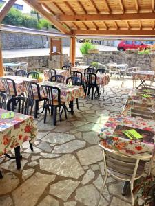 un patio con tavoli e sedie su un pavimento in pietra di Hôtel Le Bel Air a Lanuéjols