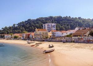 a beach with boats on the sand and houses at Trafaria Garden Beach Houses in Trafaria