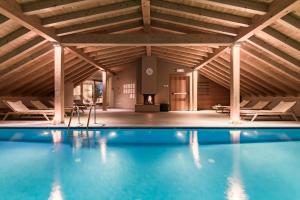 an indoor swimming pool with a wooden ceiling at Hotel Drumlerhof in Campo Tures
