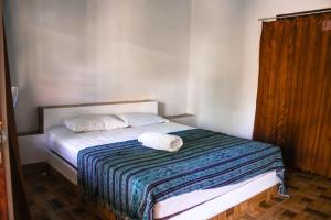 a small bedroom with a bed with two pillows at Mellow Hostel in Kuta Lombok