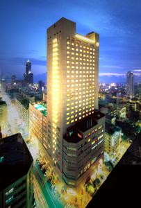 un edificio alto con luces encima en The Howard Plaza Hotel Kaohsiung, en Kaohsiung