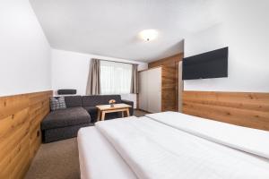 a hotel room with a bed and a couch at Ferienwohnung Haus Zyka in Neustift im Stubaital