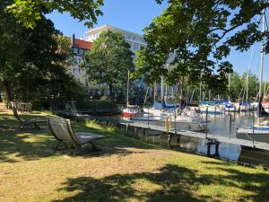 a park bench sitting next to a marina with boats at havenhome Bremerhaven in Bremerhaven