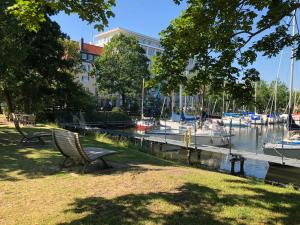 eine Parkbank neben einem Yachthafen mit Booten in der Unterkunft havenhome Bremerhaven in Bremerhaven