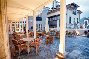 eine Terrasse mit Tischen und Stühlen in einem Gebäude in der Unterkunft Hotel Rey Silo in Pravia