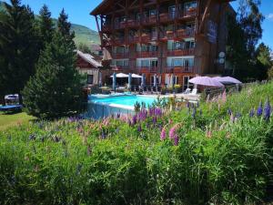 a hotel with a swimming pool in a field of flowers at Le Souleil'Or in Les Deux Alpes
