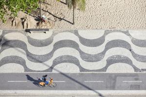 a person riding a bike on a road with a mural at PortoBay Rio de Janeiro in Rio de Janeiro