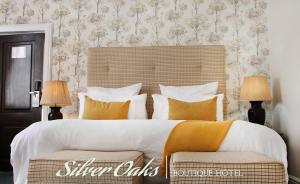 Silver Oaks Boutique Hotel في ديربان: غرفة نوم بسرير كبير ومصباحين