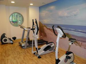 a gym with three exercise bikes and a painting at Phoenix in Kołobrzeg