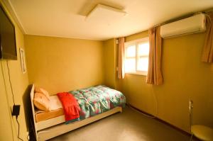 ソウルにあるコステイ ゲストハウス ソウル ステーションのベッドと窓が備わる小さな客室です。
