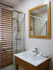 a bathroom with a sink and a shower with a mirror at The Wave Baleal in Baleal