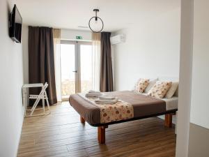 a bedroom with a bed and a large window at The Wave Baleal in Baleal