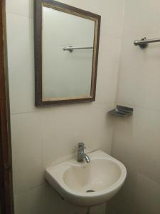 W łazience znajduje się umywalka i lustro. w obiekcie Sri Saraswathi Lodge w mieście Tiruchchirāppalli