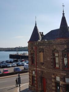 a brick building with cars parked in a parking lot at Stornoway Lido flats in Stornoway