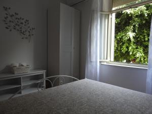 sypialnia z łóżkiem i oknem w obiekcie Casa Panco w Syrakuzach