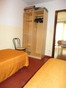 a room with two beds and a cabinet and a window at Lamoga Ona in Torredembarra