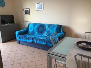 ein Wohnzimmer mit einem blauen Sofa und einem Tisch in der Unterkunft Valentina Holiday House in Mascali