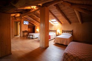 a bedroom with two beds in a room with wooden ceilings at Hotel Novoa in Sarria
