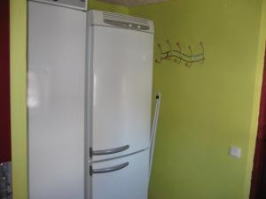Cette chambre comprend un réfrigérateur et un mur vert. dans l'établissement Piiri Holiday House, à Otepää