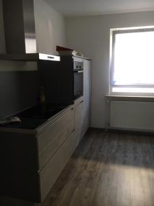 an empty kitchen with a stove and a window at Ferienwohnung Pfeifer in Friedrichsdorf