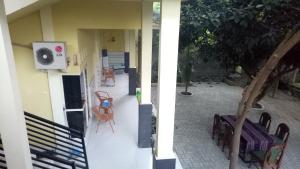 two views of a house with chairs and a building at ZONA Homestay in Selong