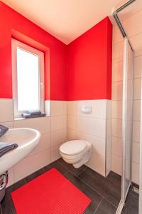 ゲーレンにあるVilla Mia Whg 4 mit Terrasse EG 1 Raum Wohnungの赤いバスルーム(トイレ、洗面台付)