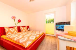 ゲーレンにあるVilla Mia Whg 4 mit Terrasse EG 1 Raum Wohnungのベッドルーム(赤いベッド1台、テレビ付)