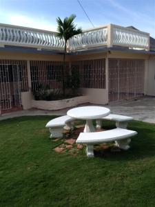 una mesa y bancos frente a un edificio en My-Places Montego Bay Vacation Home, en Montego Bay