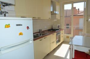 a kitchen with a white refrigerator and a sink at Casa Laura in Alassio