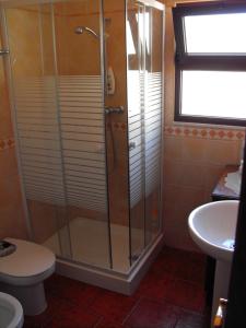 a bathroom with a shower with a toilet and a sink at Casa BENVINDHA in Degolados