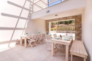 a dining room with tables and chairs and a window at Villa Ermioni Apartments in Limenaria