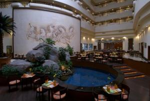 a hotel lobby with a pool and a restaurant at Taj Deccan in Hyderabad