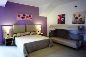 una camera da letto con un letto e due dipinti alle pareti di La Maison Rouge b&b a Ginosa Marina