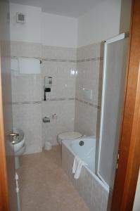 a bathroom with a toilet and a tub and a sink at Grand Hotel Moroni in Finale Ligure