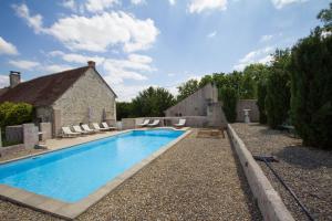 a swimming pool in the yard of a house at Le Relais de Fontenailles in Fontenailles
