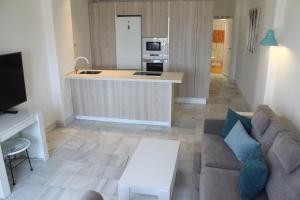 a living room with a couch and a kitchen at Kiana Mirador Puerto Sherry con parking in El Puerto de Santa María