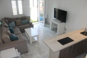 a living room with a couch and a flat screen tv at Kiana Mirador Puerto Sherry con parking in El Puerto de Santa María