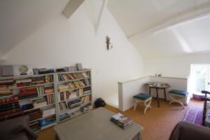 a living room with a book shelf filled with books at Le Relais de Fontenailles in Fontenailles