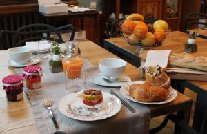 ein Tisch mit zwei Tellern Gebäck und Orangensaft in der Unterkunft Villa Élyane in Colmar