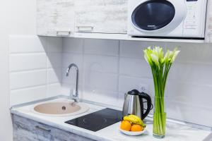 a kitchen counter with a sink and a vase of flowers at Smart apartment проспект Гагарина in Dnipro