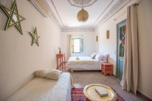 a room with a bed, a desk, and a painting on the wall at Ksar Kasbah & Spa in Marrakech