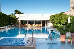 a swimming pool with a jacuzzi in a hotel at Hotel Derby Exclusive in Milano Marittima