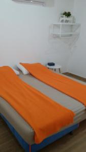a bedroom with an orange blanket on a bed at A Place To Remember in Ma‘alot