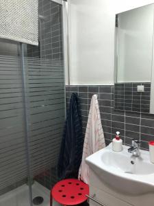 łazienka z umywalką i czerwonym stołkiem w obiekcie Damas 3 w mieście Cáceres
