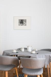 einen Esstisch mit Stühlen und ein Bild an der Wand in der Unterkunft Le Meridien by Cocoonr in Rennes