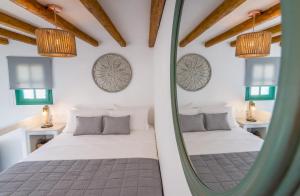 Babounis Suite في Péran Triovasálos: غرفة نوم بسريرين ومرآة